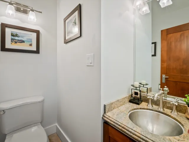Half bath featuring baseboards, toilet, and vanity