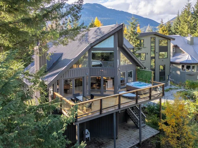 Rear view of property featuring board and batten siding, a deck with mountain view, stairway, a standing seam roof, and metal roof