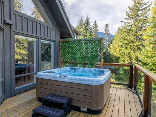Wooden terrace featuring a mountain view and a hot tub