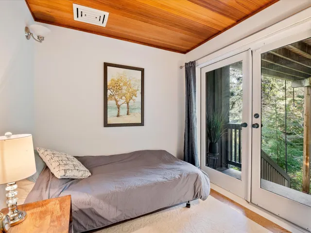 Bedroom featuring visible vents, wood finished floors, access to outside, and wood ceiling