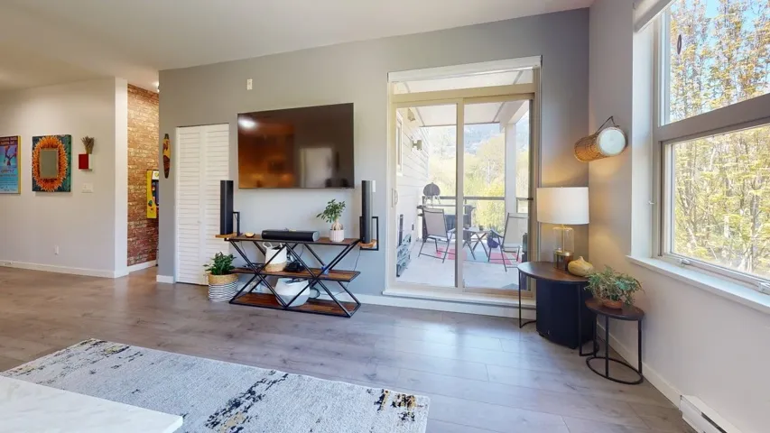 Living room featuring  a wealth of natural light and access to a weather protected outdoor living space.