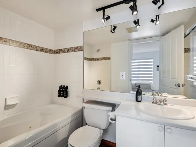 Bathroom featuring  shower combination, visible vents, vanity, and toilet