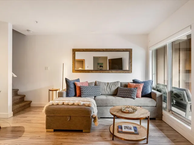 Living area with stairway, light wood-style flooring, and baseboards