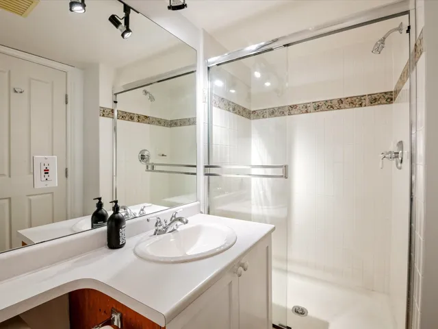 Full bathroom featuring a stall shower, vanity, and visible vents