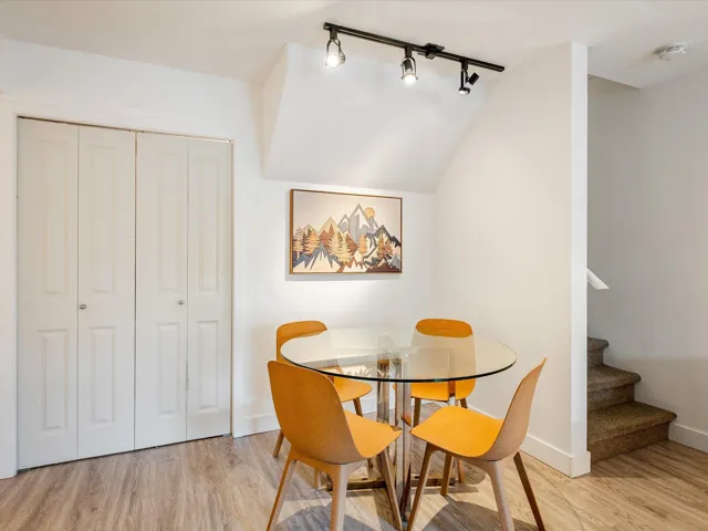 Dining space with light wood-style flooring, stairway, and baseboards