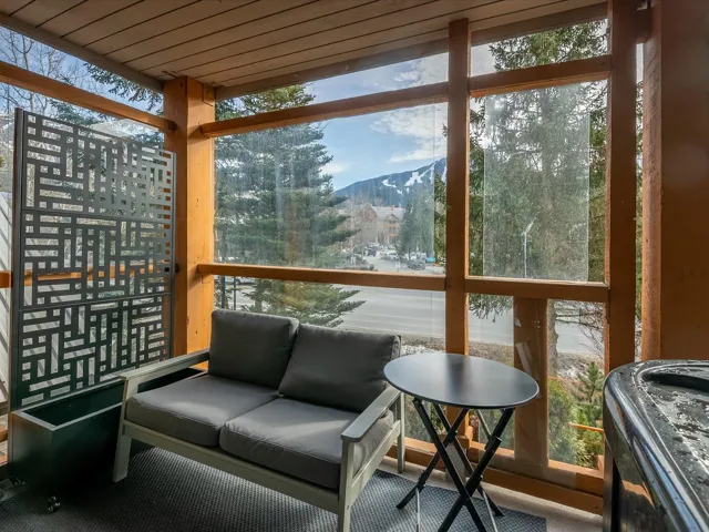 Sunroom / solarium with wooden ceiling and a mountain view