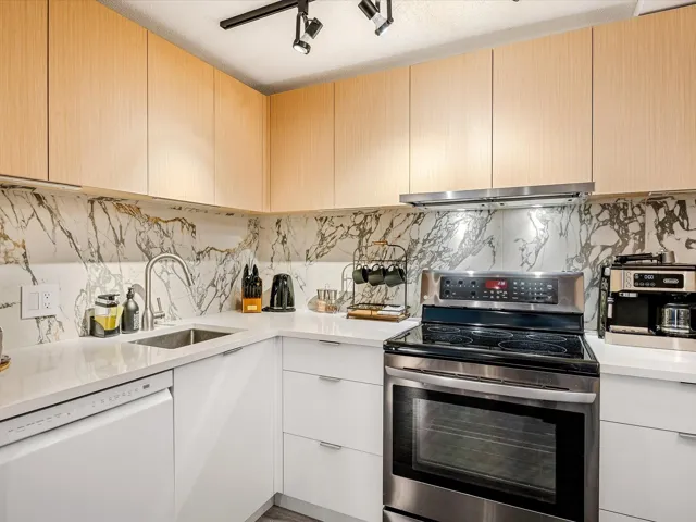 Kitchen with extractor fan, a sink, electric stove, light countertops, and dishwasher
