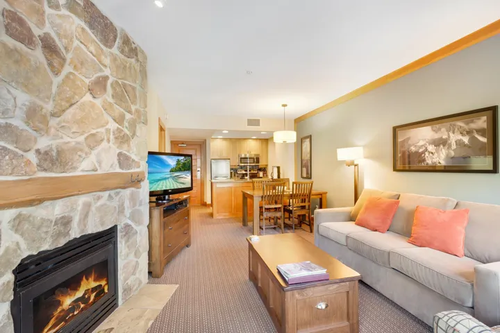 Living room featuring light carpet, a fireplace, visible vents, and crown molding