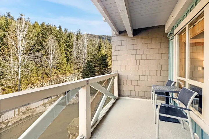 Balcony featuring a wooded view