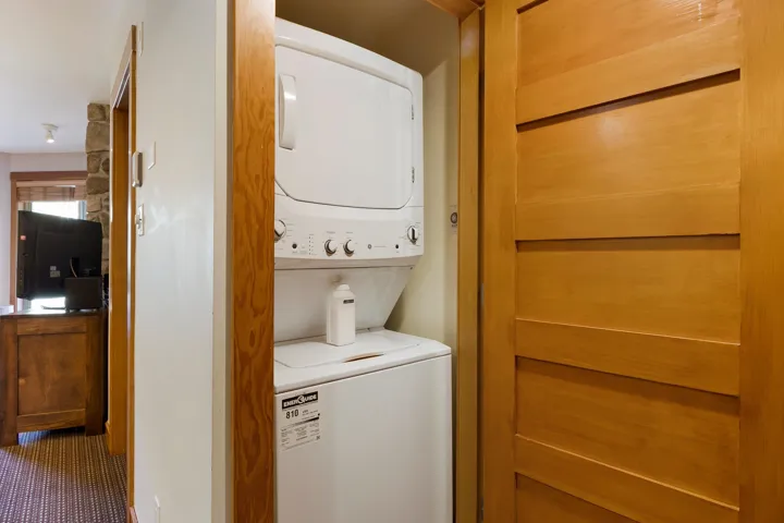 Laundry room featuring stacked washer / drying machine and laundry area