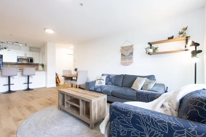 Living area with rail lighting and light wood-style flooring