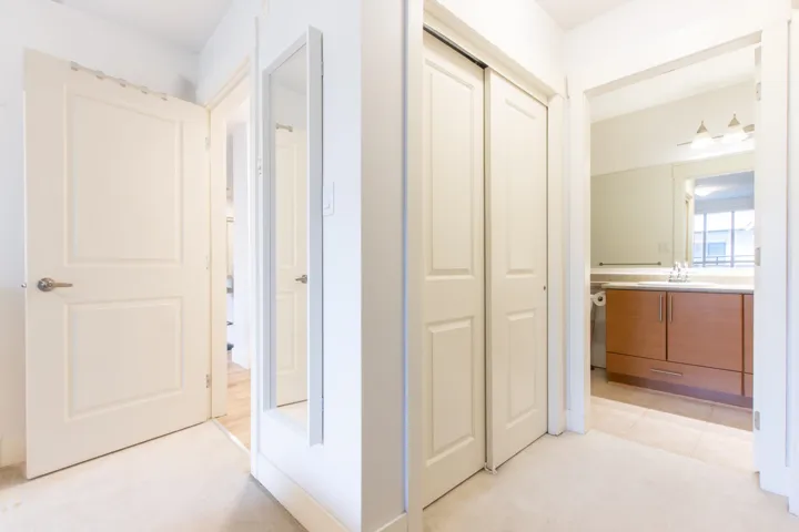 Hallway featuring light carpet and a sink