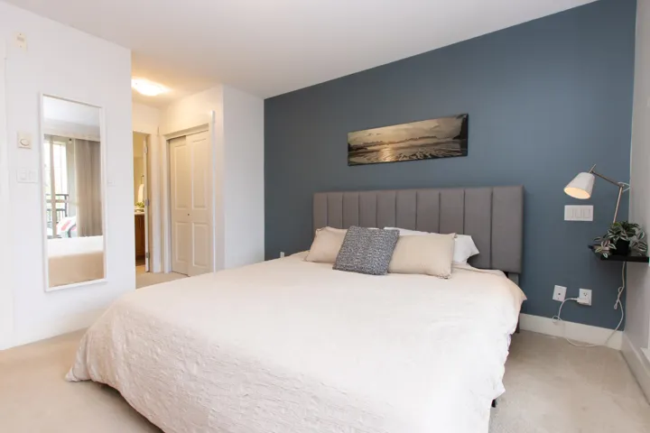 Bedroom with baseboards, a closet, and light carpet