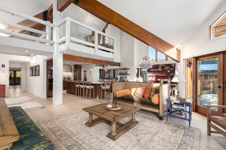 Living room with light wood-style floors and lofted ceiling