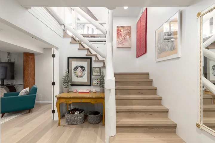 Stairway with wood finished floors and recessed lighting