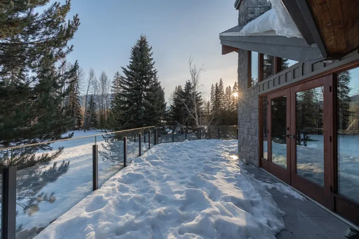 Snowy yard featuring french doors and view of scattered trees