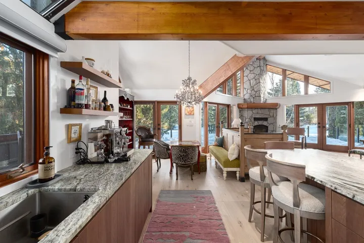 Kitchen with a fireplace, french doors, light wood-type flooring, and light stone countertops