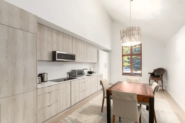 Dining space with light wood-type flooring, hanging lights, and lofted ceiling