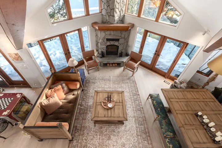 Living room featuring french doors, a fireplace, wood finished floors, and vaulted ceiling