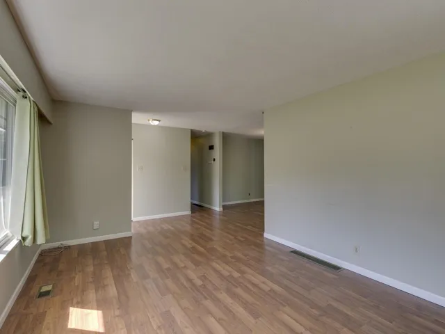 Unfurnished room with wood finished floors and baseboards