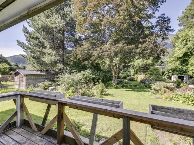 Wooden deck with a shed, a vegetable garden, and a mountain view