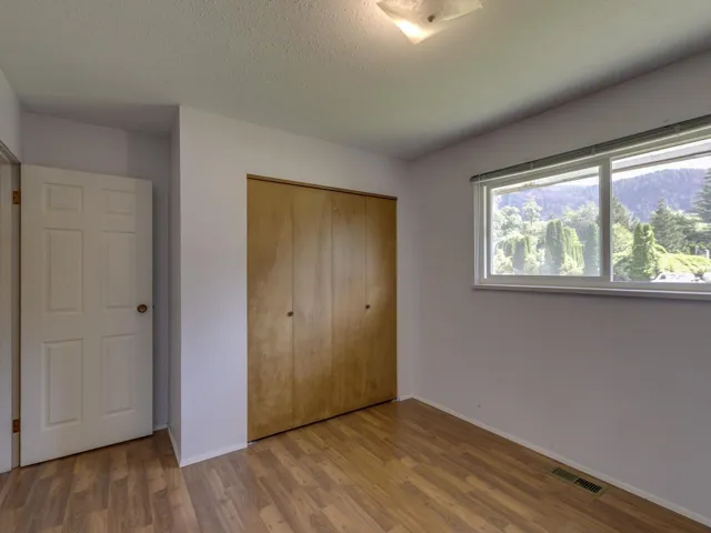 Unfurnished bedroom featuring wood finished floors, a closet, and a textured ceiling
