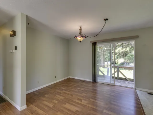 Unfurnished dining area featuring wood finished floors and a chandelier