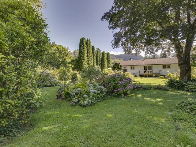View of grassy yard featuring a deck