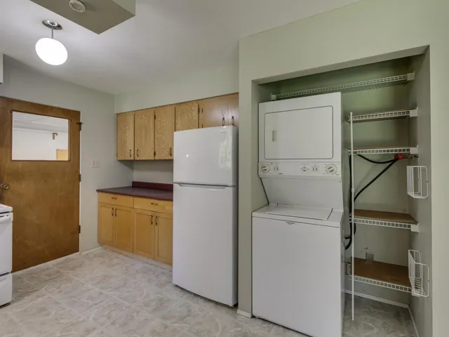 Laundry room with stacked washer and clothes dryer