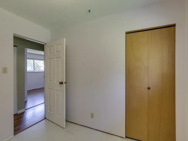Unfurnished bedroom with light floors and a closet