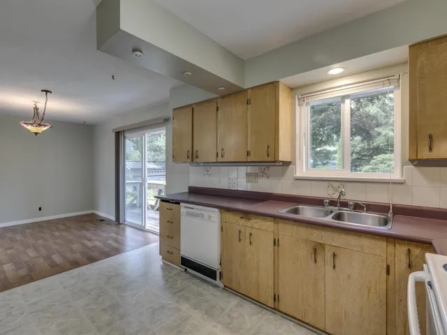Kitchen with tasteful backsplash, white appliances, dark countertops, pendant lighting, and recessed lighting