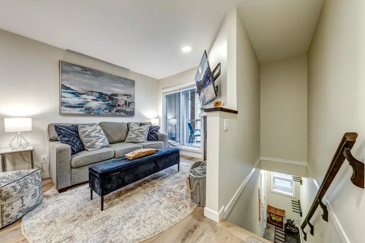 Living area featuring wood-finish flooring, recessed lighting, and a sliding glass door to an outdoor space