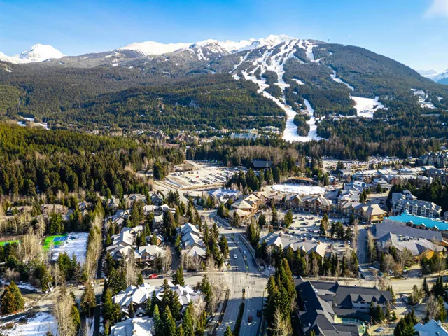 Aerial perspective of a mountain resort community with snow-capped peaks