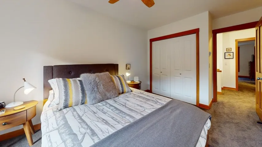 Carpeted bedroom featuring a closet and a ceiling fan