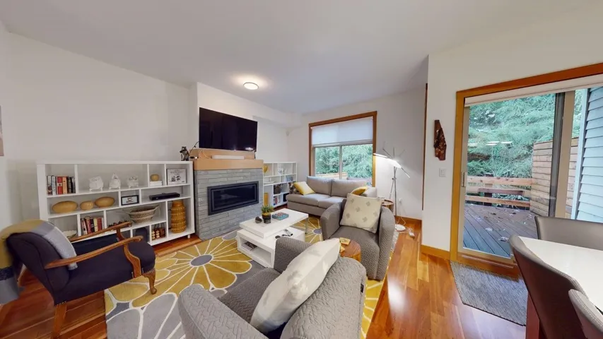 Living area with a glass covered fireplace and wood finished floors