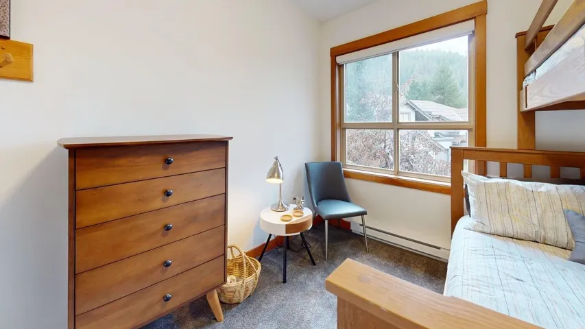 Bedroom with a baseboard heating unit and dark colored carpet