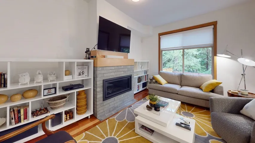 Living room featuring wood finished floors and a brick fireplace