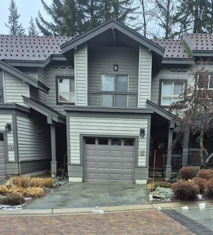 View of front of property featuring a balcony and a garage