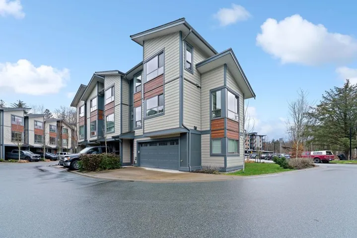 View of property exterior featuring a garage and driveway