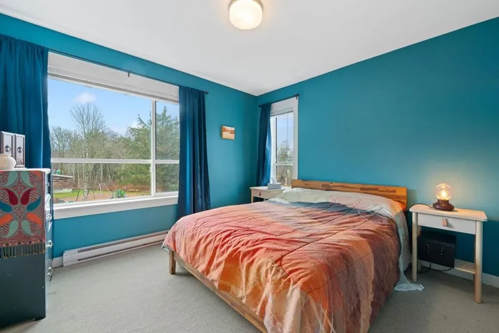 Bedroom featuring a baseboard radiator, baseboards, and carpet flooring