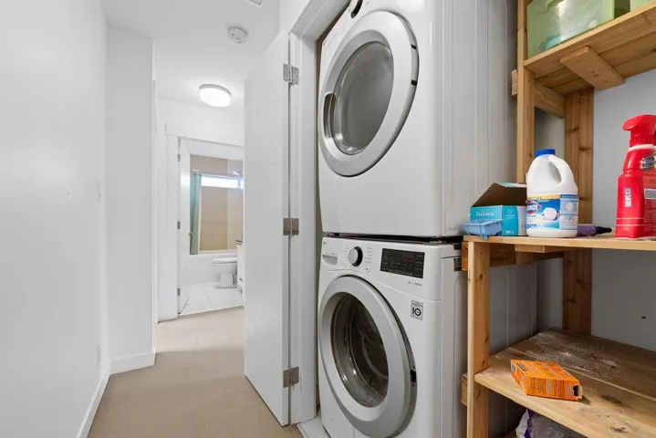 Washroom featuring carpet flooring and stacked washer / drying machine
