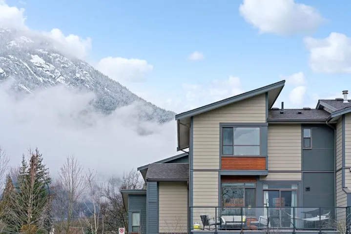 Rear view of property with a mountain view and roof with shingles