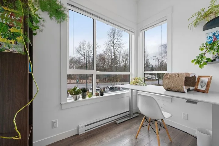 Home office with a baseboard heating unit, wood finished floors, and baseboards