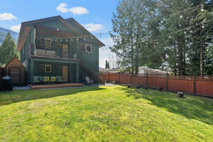 Rear view of house featuring a wooden deck, a fenced backyard, and an outbuilding