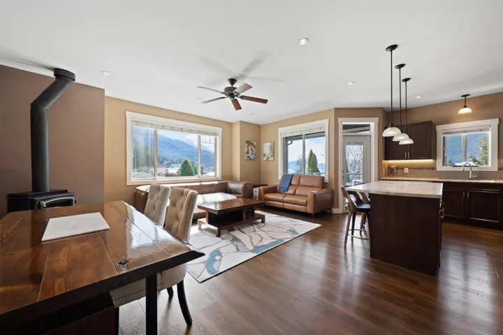 Open concept living area with large windows and a wood burning fireplace