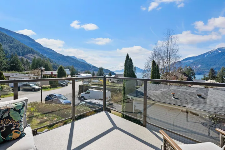 Front corner patio overlooking Howe Sound, featuring an outdoor living space with a fire pit and area for grilling