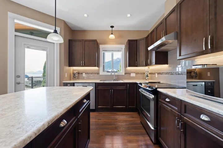 Kitchen featuring light countertops, open floor plan, pendant lighting, and wood finish cabinets