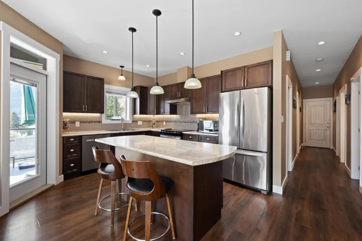 Kitchen featuring light countertops, open floor plan, pendant lighting, and wood finish cabinets