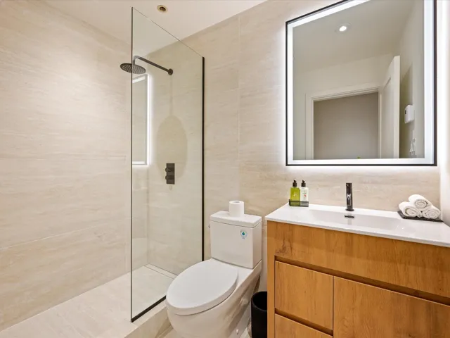 Full bathroom with vanity, walk in shower, tile walls, and recessed lighting