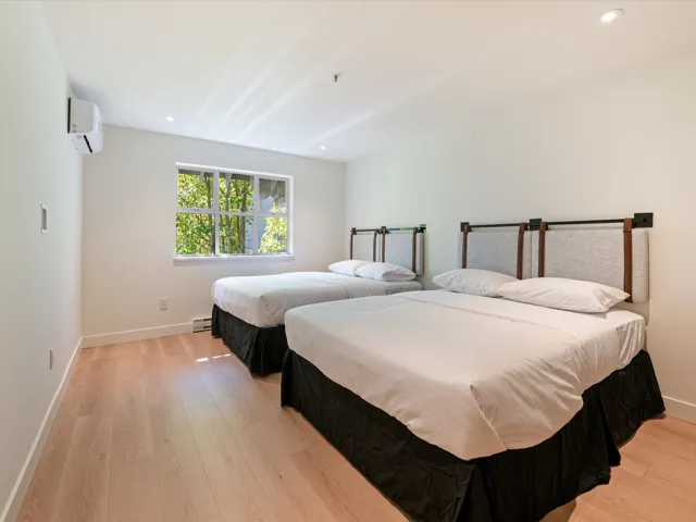 Bedroom featuring recessed lighting, light wood-style floors, an AC wall unit, and a baseboard heating unit